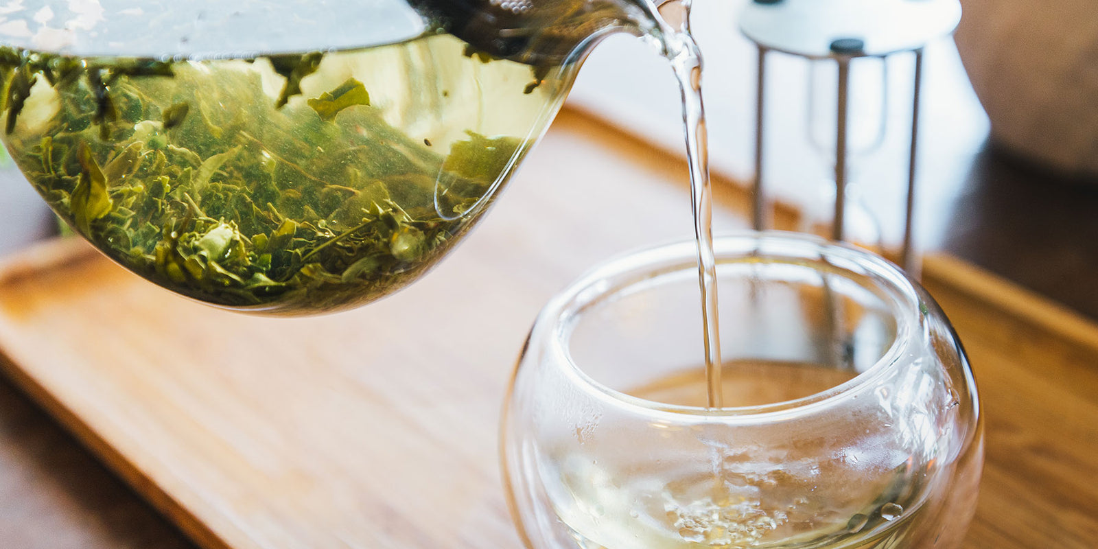 Long Jing Green tea pouring from glass teapot